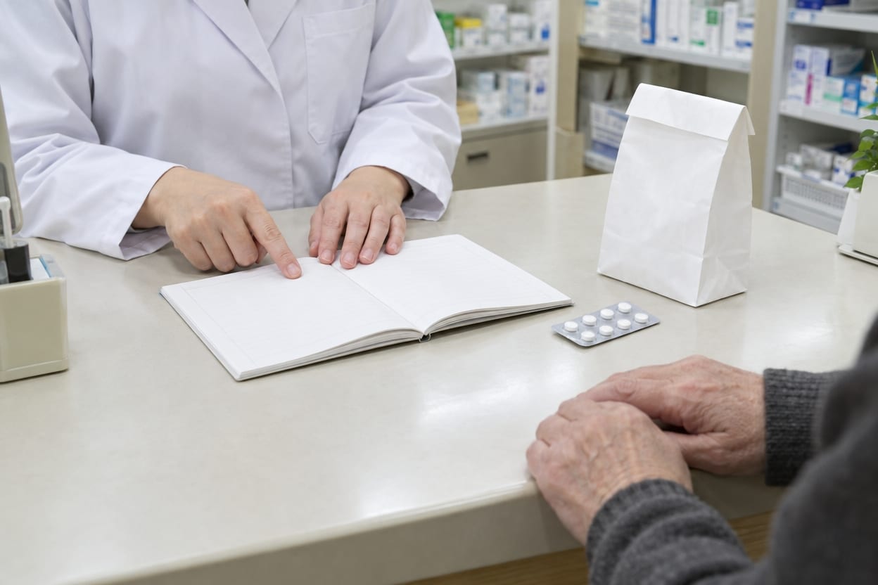 薬剤師がお薬手帳を見ながらお薬の説明をしているイメージ