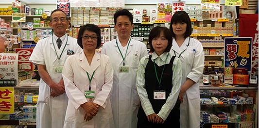 白衣のスタッフ5名が店内に並んだ写真